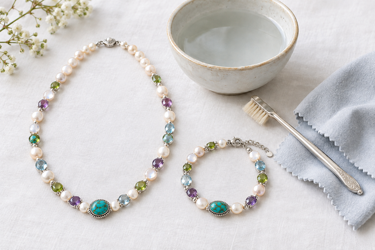Pearl and gemstone bracelet and necklace on white linen with a soft cloth and cleaning brush — how to safely clean silver jewellery with natural stones and pearls