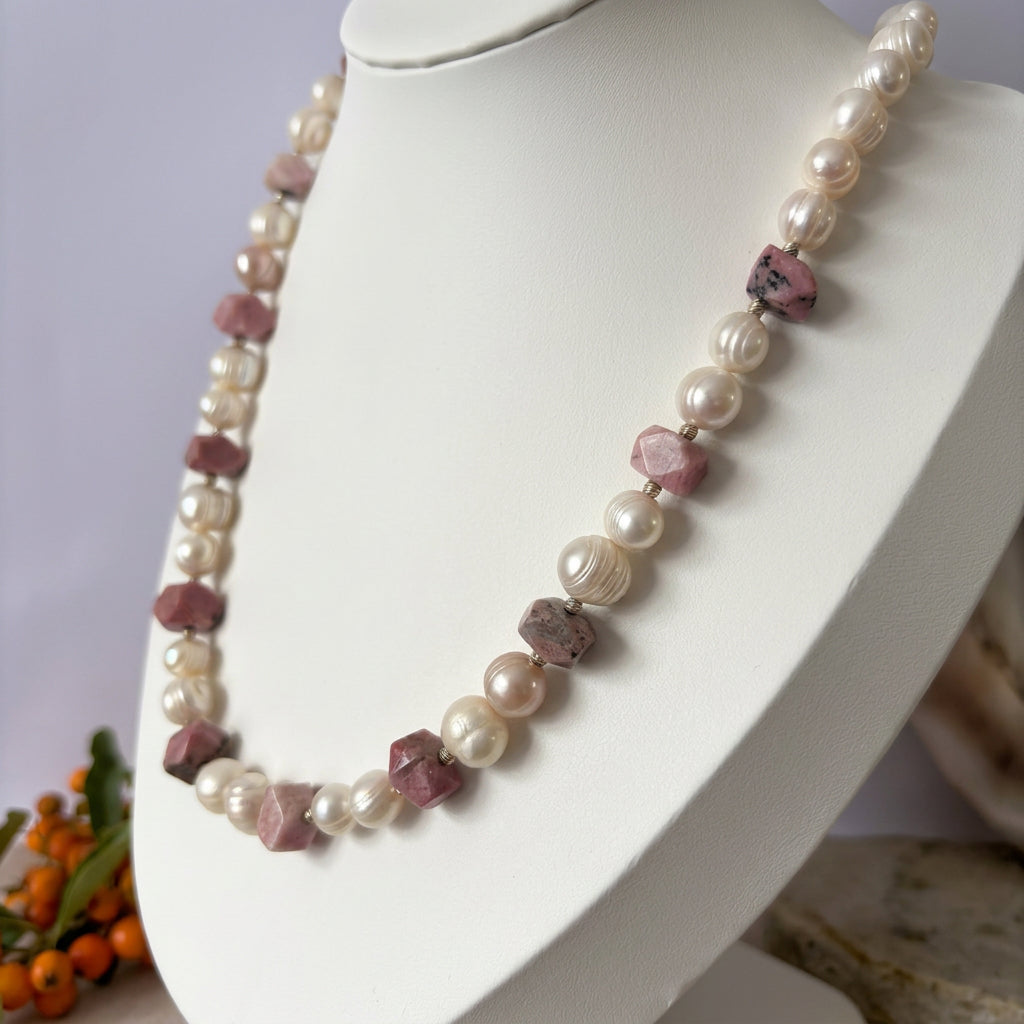 White baroque pearl and pink opal necklace displayed on a white bust, showing pairs of lustrous ridged pearls between irregular faceted pink stones and small sterling silver spacers.