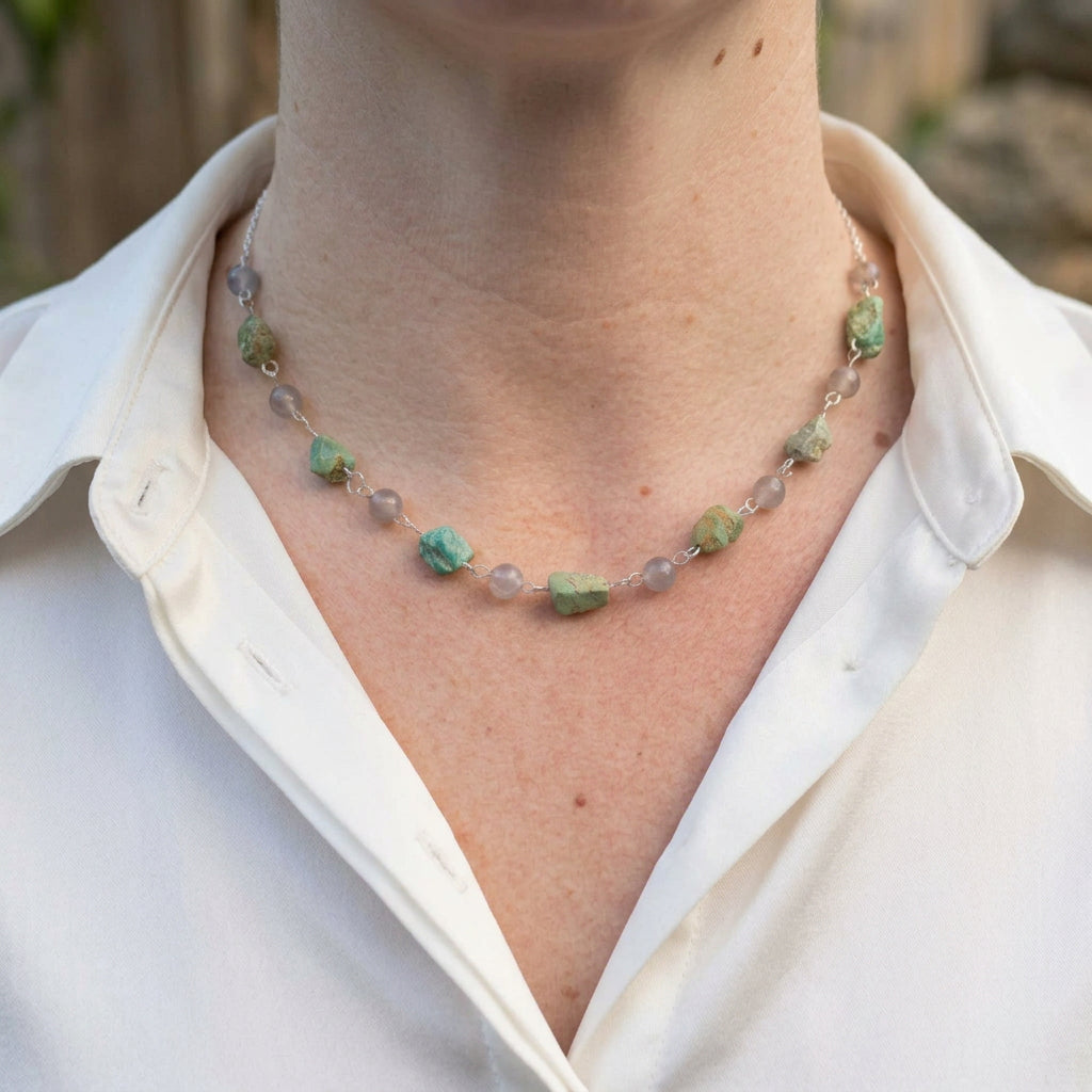 Raw Hubei turquoise and labradorite necklace worn with an open-neck white shirt, showing irregular green-blue stones alternating with round grey labradorite beads, joined by handmade sterling silver wire links.