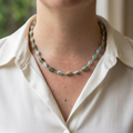 Raw Hubei turquoise and larimar necklace worn with an open-neck white shirt, showing irregular green-blue turquoise alternating with pale blue larimar stones, joined by handmade sterling silver wire links.