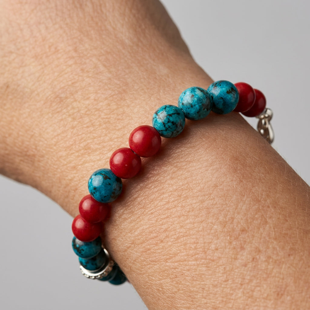 Blue agate and red coral bracelet worn on a wrist, showing mottled blue beads interspersed with glossy red beads.