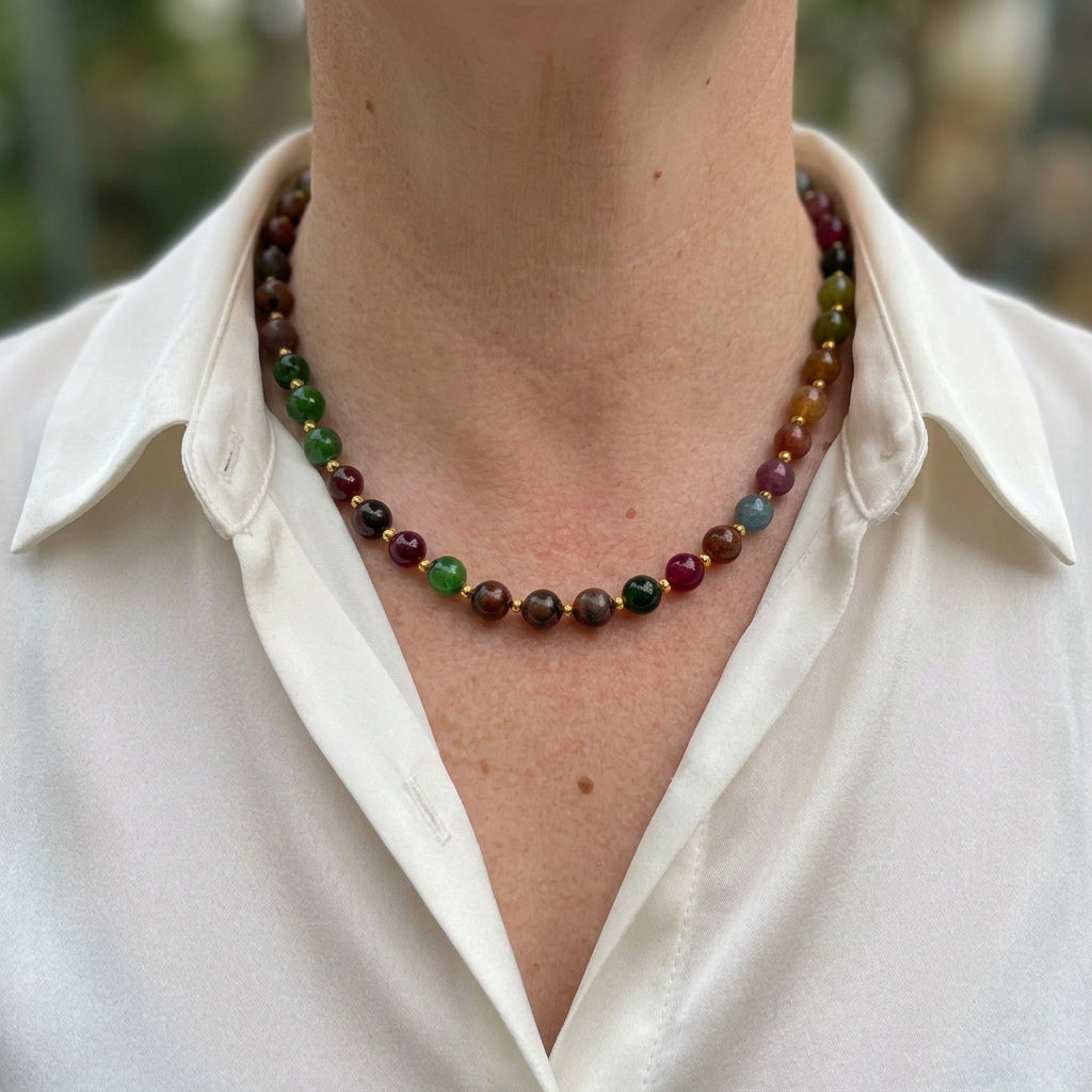 Blue jasper, carnelian, yellow topaz and white pearl necklace worn with an open-neck white shirt, showing mottled blue-green beads, rich orange-red stones, bright yellow accents and small gold-coloured spacers.