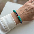 Lapis lazuli and stabilised Hubei turquoise bracelet worn on the wrist, showing dark blue and green-blue beads with silver spacers.