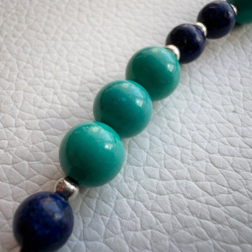 Lapis lazuli and Hubei turquoise bracelet on cream linen, showing groups of green-blue turquoise beads between dark blue lapis lazuli.