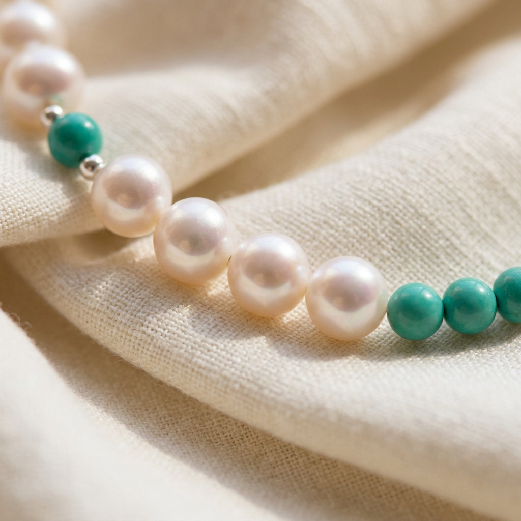 White baroque pearls beside grouped Hubei turquoise beads, with sterling silver details on cream linen.