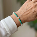 White baroque pearl and Hubei turquoise bracelet worn beside a white cuff, showing grouped turquoise beads and sterling silver details.