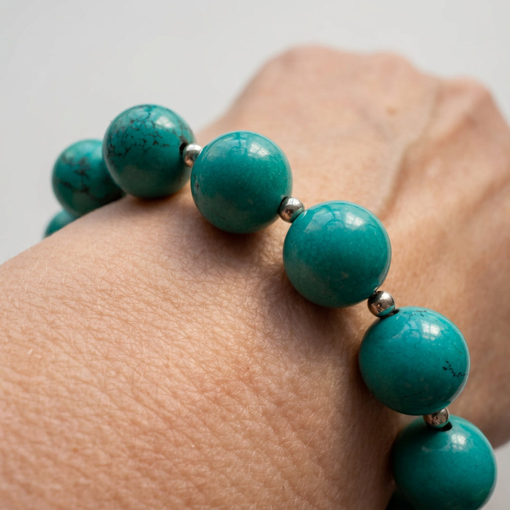 Close-up of 11mm Hubei turquoise beads and small sterling silver beads worn on the wrist.