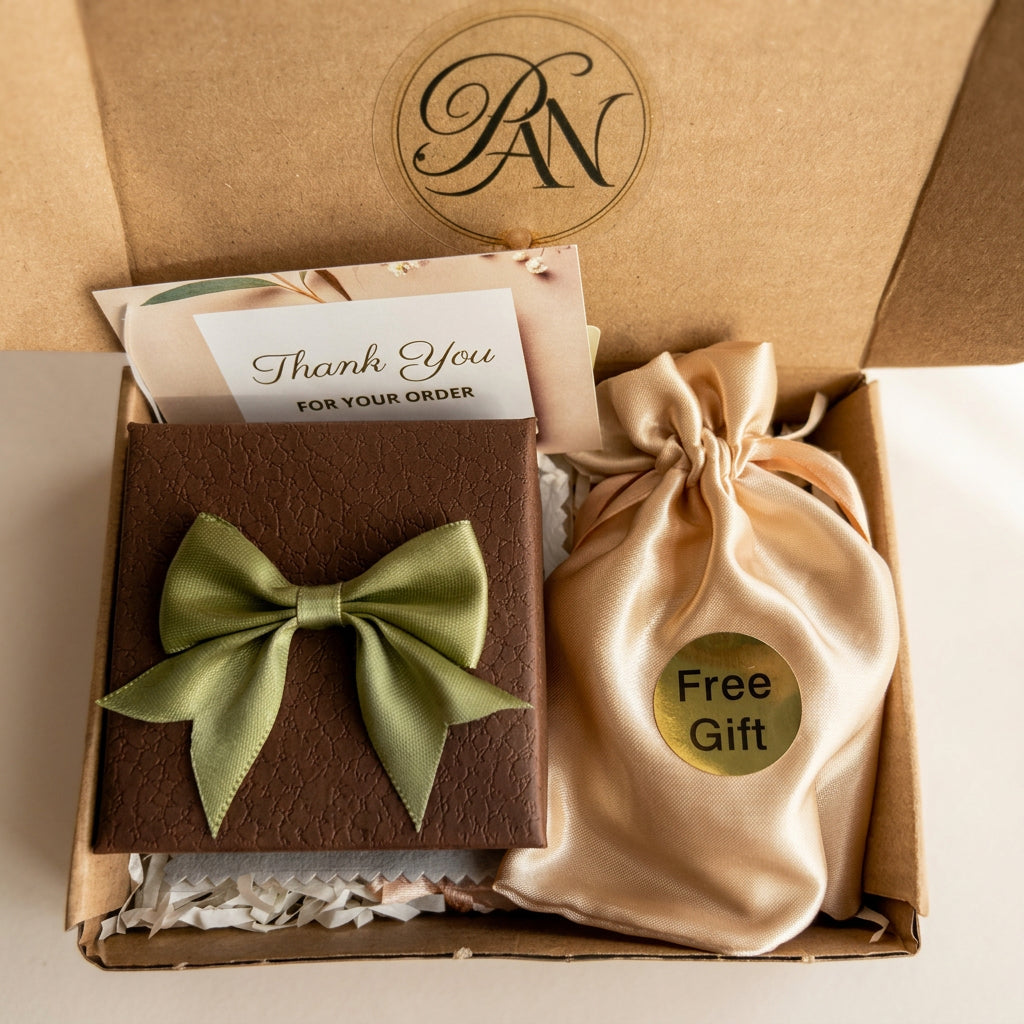 Pearl Art Nature brown jewellery box with a green satin bow, thank-you card and gold satin pouch labelled “Free Gift”.

