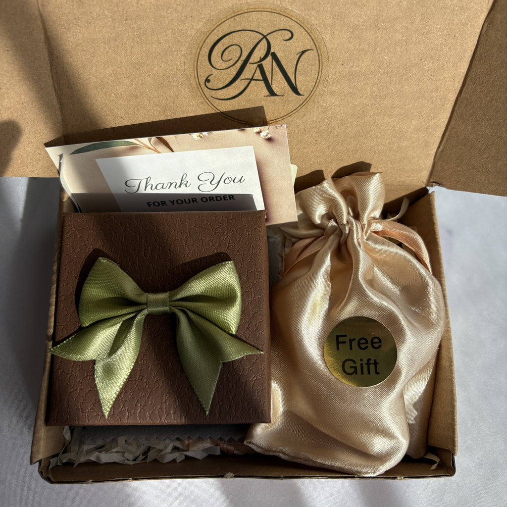 Pearl Art Nature gift packaging in an open kraft box, with a brown jewellery box tied with a green satin bow, a thank-you card and a cream satin pouch labelled “Free Gift”.