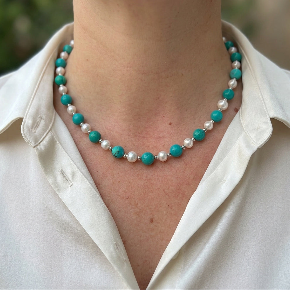 Hubei turquoise and white baroque pearl necklace worn with a white collared shirt, showing alternating green-blue beads and pearls.