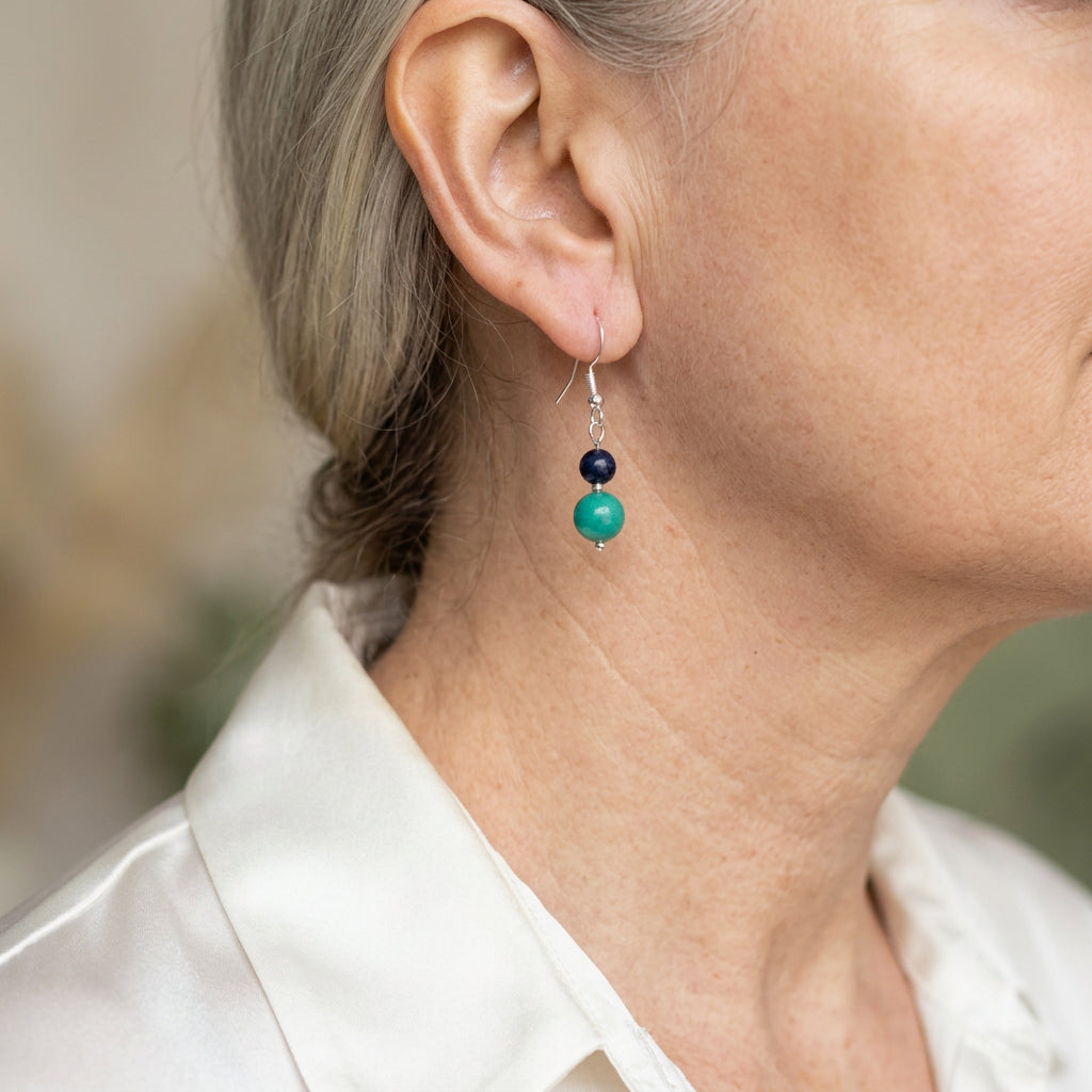 Sterling silver drop earring worn on the ear, with a small dark blue lapis lazuli bead above green-blue Hubei turquoise.